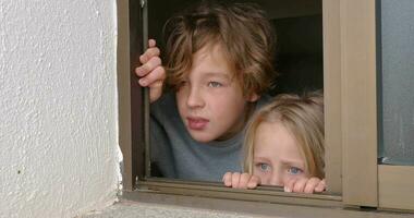 Schwester und Bruder suchen draußen durch das öffnen Haus Fenster video