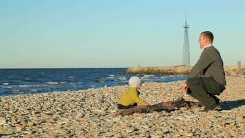 Vater und Sohn spielen auf Kieselstein Strand video