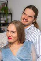 Happy couple with beautiful long hair in blue clothes, smiling and looking ahead photo