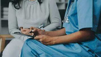 médecin et patient séance et parlant à médical examen à hôpital bureau, fermer. thérapeute remplissage en haut des médicaments histoire enregistrements. médicament et soins de santé concept. video