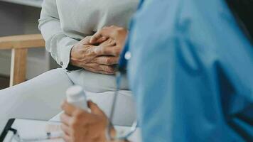 Doctor and patient sitting and talking at medical examination at hospital office, close-up. Therapist filling up medication history records. Medicine and healthcare concept. video