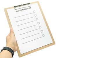 Hand holding Blank checklist paper during safety audit and risk verification for text. Empty safety checklist form isolated on white background. photo