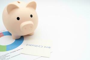 Concept of emergency savings fund. A piggy bank with paper note Pension Plan. Piggy bank and graph for saving emergency money. photo