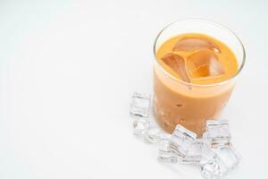 Glass of thai iced tea with ice cube on white background. photo