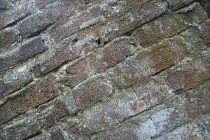 Weathered brick layer wall background, grungy brick texture surface, aged wall texture photo