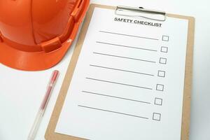 Blank checklist paper during safety audit and risk verification. safety checklist form with Hard hat or Safety hat. photo
