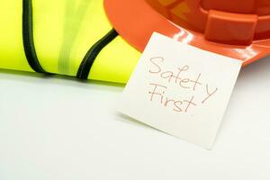 Safety First message on paper. Safety Gear. Reflective vest and safety hat or helmet. Safety First Concept. photo