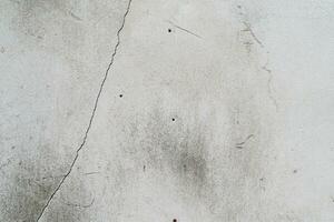 grieta blanco hormigón pared textura. textura, muro, concreto, eso lata ser usado como un antecedentes. pared fragmento con arañazos y grietas foto