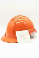 Orange safety hat with message Safety First. hard hat isolated on white background. photo