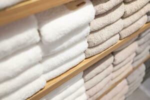 White towels on the shelves in the store. Stack of towels in a shop. photo