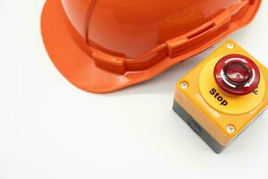 Orange safety hat with Emergency Stop Button isolated on white background. Safety First Concept. photo