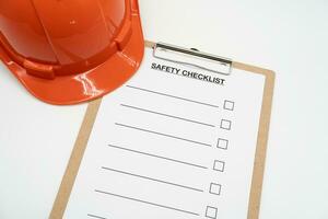 Blank checklist paper during safety audit and risk verification. safety checklist form with Hard hat or Safety hat. photo