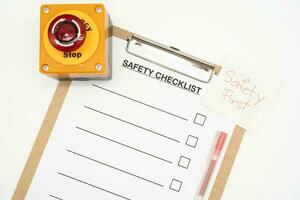 Safety First Text Note. Blank checklist paper during safety audit and risk verification. safety checklist form with Emergency Stop Button. photo