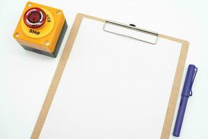 Blank clipboard paper, Emergency stop button and Pen isolated on white background. photo