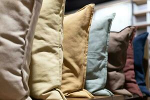 Row of decorative pillows on a store shelf. Many pillows are in a row. photo