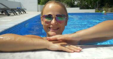 Frau im Sonnenbrille genießen sonnig Tag im das Schwimmbad video