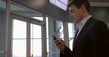 homme d'affaire bavardage sur le téléphone à aéroport video