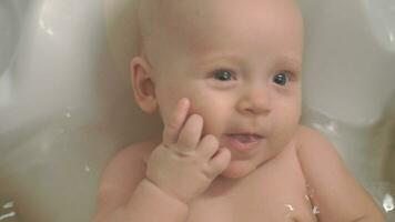 un de cerca de un bebé niña disfrutando baños video