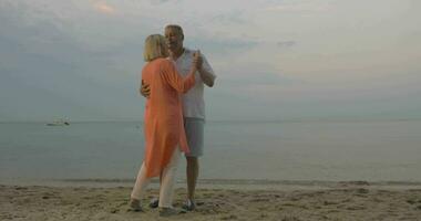 Senior casal dançando em a de praia video