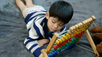 asiatisk pojke spelar med leksaker på de säng video