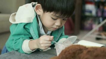 A boy happily uses a spoon to scoop up yogurt. video