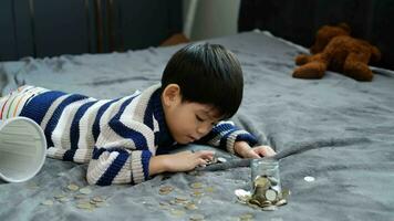 Asian boy happily counting coins to save money video