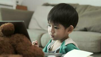 asiático chico estudiando en línea y haciendo ocupaciones en ordenador portátil video