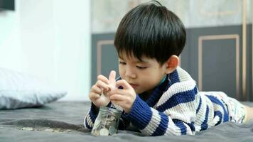 Asian boy happily counting coins to save money video