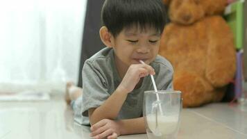 asiático chico es Bebiendo un vaso de Leche video