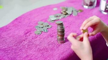 Asian boy arranging coins in a row to practice saving money video