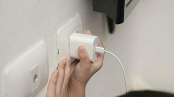 A child's hand is taking out the charger to save power. video