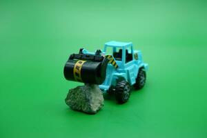 tandem roller toy in blue color isolated on green background. tandem rollers pushing rocks. photo