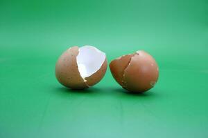 broken eggshell over green background. empty eggshells. photo