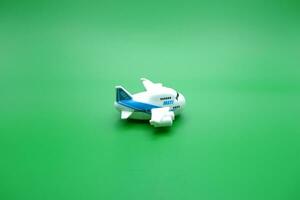 mini airplane toy isolated green background. white and blue airplane toy. photo