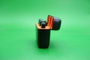 wireless mic with its charging case on a green background photo