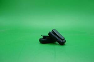 a pair of wireless mics over a green background. wireless mic that is usually used by content creators. photo