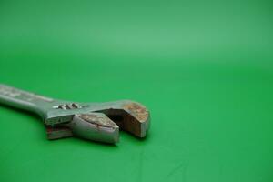 a wrench on a green background. wrench that has started to rust. photo