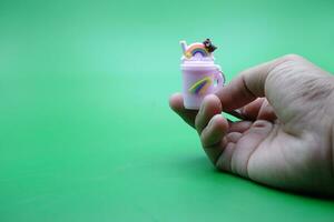 hand holding a cute key chain on a green background photo