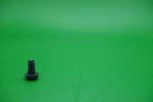 a toy screw on a green background photo