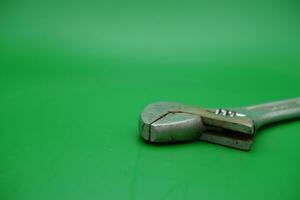 a wrench on a green background. wrench that has started to rust. photo