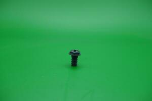 a toy screw on a green background photo