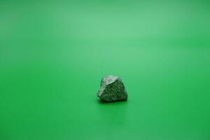 a small stone isolated green background. stone used for building materials. photo