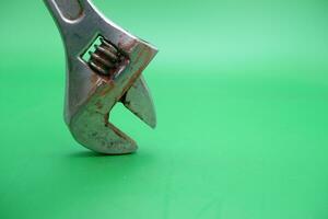 a wrench on a green background. wrench that has started to rust. photo