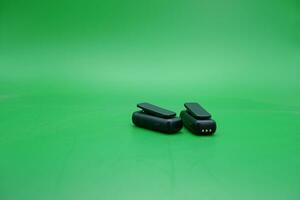 a pair of wireless mics over a green background. wireless mic that is usually used by content creators. photo