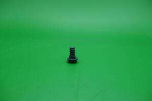 a toy screw on a green background photo