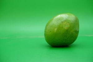 un aguacate metido en el medio de un verde antecedentes. foto