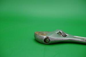 a wrench on a green background. wrench that has started to rust. photo