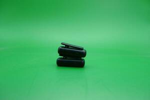 a pair of wireless mics over a green background. wireless mic that is usually used by content creators. photo