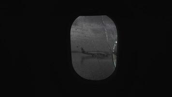 Illuminator with rain streaks, view to airport from moving plane video