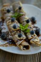 un plato coronado con crepes y arándanos foto